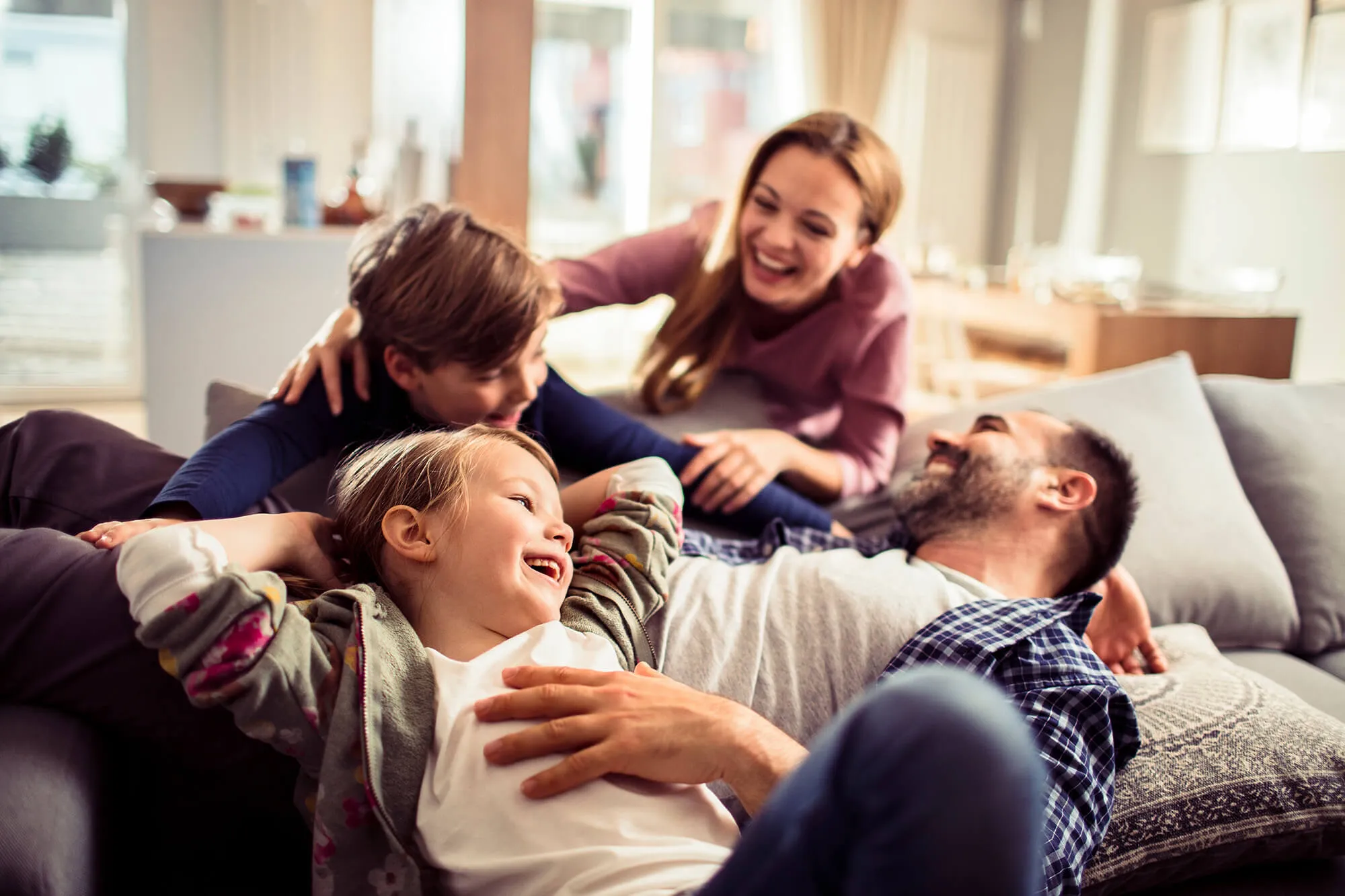 Happy young family relaxing on the couch together at home